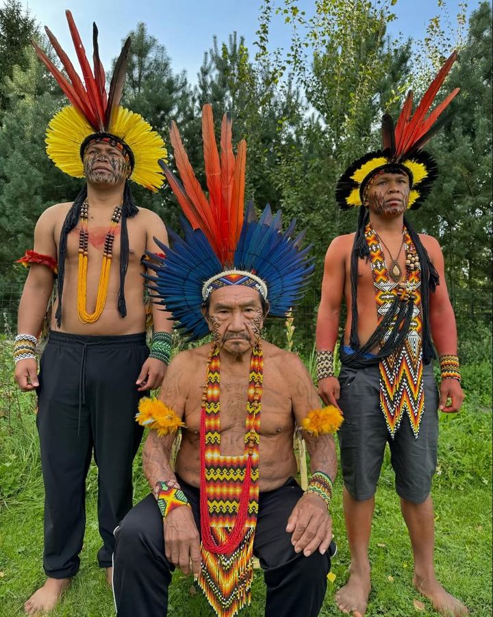 Quatro homens Noke Koî com cocares coloridos