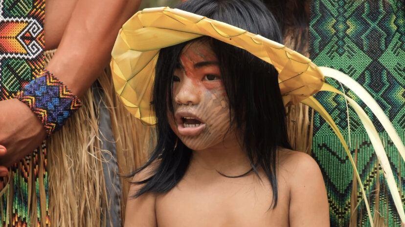 Menina com chapéu de palha e pintura no rosto